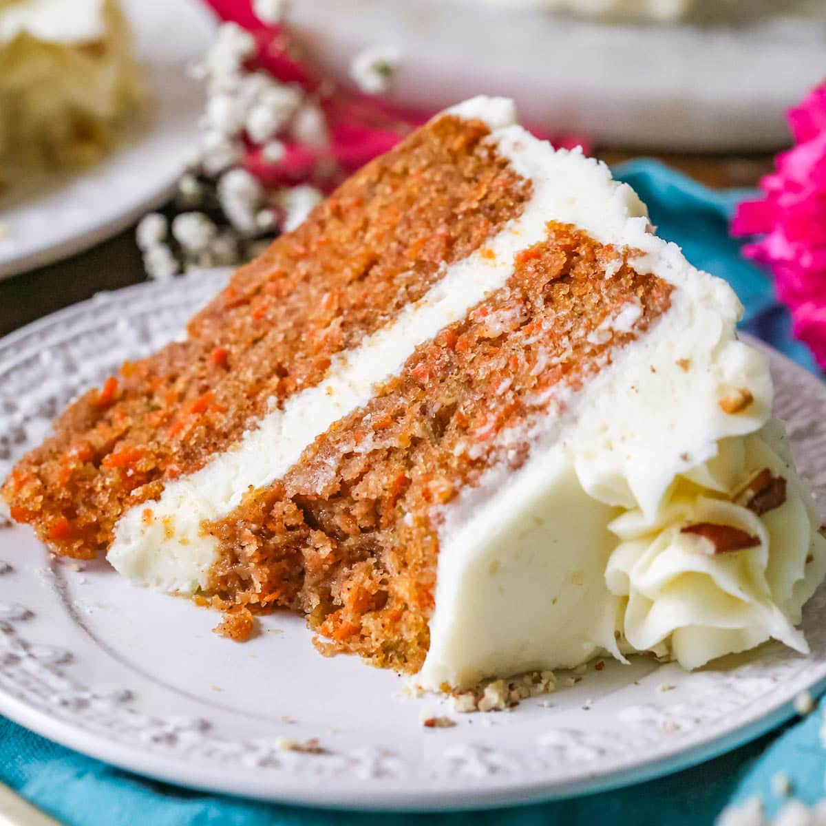 عکس کیک هویج برش خورده داخل بشقاب به همراه خامه